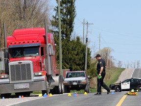 A OPP Technical Traffic Collision Investigator looks over the scene of a crash involving a transport truck and a pickup truck in Colborne, Ont. in this file photo.
