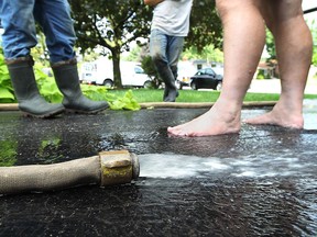 Residents talk as they pump out a basement on Atlantic Avenue after rain caused flooding in several areas of Amherstburg on Tuesday, Aug. 9, 2011.