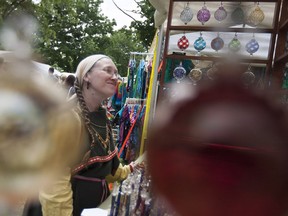 Diane Pepin checks out hand crafted ornaments from La Glasserie during Art in the Park at Willistead Park, Saturday, June 4, 2016.