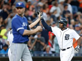 Detroit Tigers' Justin Upton, right, celebrates his two-run home run as Toronto Blue Jays pitcher J.A. Happ walks back to the mound in the third inning of a baseball game, Monday, June 6, 2016 in Detroit.