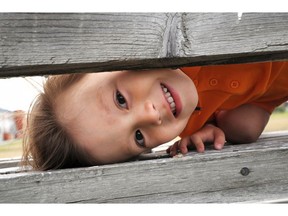 Boy playing and looking over wooden boards. Photo by Getty Images.