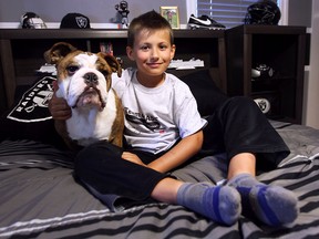 Chase Delisle is shown at his Windsor, Ont. home with his dog Mack on Thursday, June 9, 2016. The 8-year-old was diagnosed with a brain tumour and will be participating as the guest of honour in a fundraising walk this upcoming weekend.