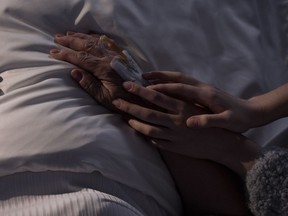 The hands of a daughter touch those of her ill mother in this photo illustration.