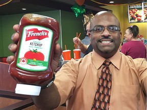 Brian Fernandez proudly displays a couple of bottles of French's ketchup at the A&W restaurant in Leamington on Thursday, June 23, 2016. The Orillia resident made a video promoting French's ketchup that went viral. The A&W restaurant was giving away free burgers during the lunch hour to promote the use of all the Canadian ketchup.