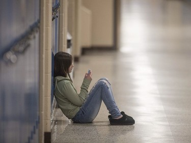 Lexie Lamarche, an 18-year-old grade 12 student, sits in the hallway on her spare at Harrow District High School, Thursday, June 16, 2016.  The school is to be closed for good after this school year.
