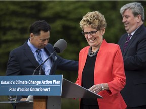 Ontario Premier Kathleen Wynne arrives to make an announcement on a climate change policy with Ontario Minister of Economic Development, Employment and Infrastructure Brad Duguid, left, Ontario Minister of the Environment and Climate Change Glen Murray, right, at Evergreen Brickworks in Toronto on June 8, 2016.