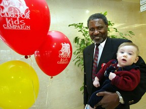 Pediatrician Dr. Joe Galiwango gets a little help from six month old Chad Kristalovich in kicking off the We Care For Kids Campaign at Windsor Regional Hospital in this 2002 file photo.