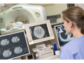 Nurse monitoring patient having a Computerized Axial Tomography (CAT) Scan sitting down at desk. Photo by Getty Images.