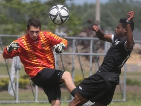 E.J. Lajeunesse goalkeeper Alex Cyrenne (L) and Jeremy Bangala of Saint-Charles Granier battle for the ball during OFSAA soccer championships on Thursday, June 2, 2016, at McHugh Park.