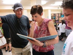 A school closing ceremony was held at Percy P. McCallum Public School in Windsor on Friday, June 24, 2016. The school on Milloy Street will close after 61 years. Gary Galli, left, his daughter Melissa Beaton and grandson Cameron Beaton look at old photos in the library. They all attended the school.