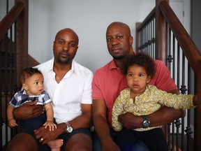 Paul Galiwango and his seven-month-old son Paul Jr., left, pose with brother Joseph Galiwango and with his daughter, 16-month-old Dominique, at Paul's Pickering home on June 16, 2016. Paul and Joseph's father, Dr. Joe Galiwango, a huge figure in the Windsor community, was found dead last week, having never met his grandchildren Paul Jr. and Dominique.