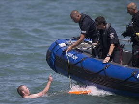 A man refuses requests from the Windsor police to exit the water while swimming in the Detroit River, Sunday, June 19, 2016. The man was in the water for nearly an hour.