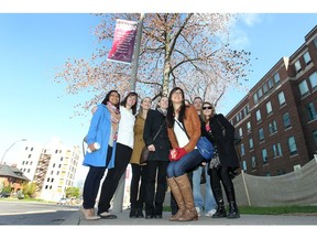 In this file photo, to honour the first batch of graduates from Windsor's medical school, Hotel-Dieu Grace Hospital and the city have temporarily re-named a stretch of Ouellette Avenue, Schulich Way. Some of the members of the charter class pose for a photo Monday, April 2, 2012, in front of one of the banners. (DAN JANISSE/The Windsor Star).