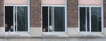 Students at Walkerville Collegiate look out windows on Wednesday, June 22, 2016, during a hold and secure period while police investigated a shooting in the area.