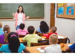 Teacher teaching her classroom of students at the elementary school. Photo by Getty Images.