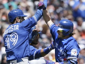 Josh Donaldson #20 of the Toronto Blue Jays is congratulated by Jose Bautista #19 and Edwin Encarnacion #10 after hitting a three-run home run against the Detroit Tigers during the third inning at Comerica Park on June 8, 2016 in Detroit, Mich.