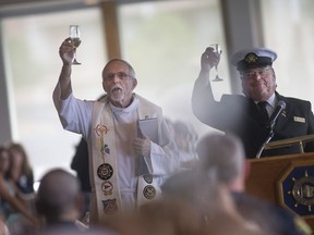 Fleet chaplain, Rev. Stan Fraser, left, and past Windsor Yacht Club commodore, Randy Moir, raise a glass during the Dedication of the Harbour at the Windsor Yacht Club, Sunday, June 5, 2016.