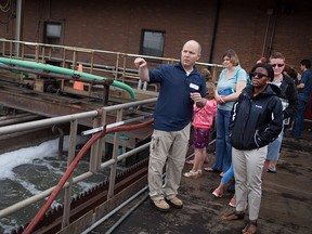 Chris Manzon, left, senior pollution control manager at the Lou Romano Water Reclamation Plant, gives a tour of the plant during an open house in this June 2015 file photo.