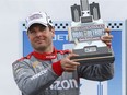 Will Power celebrates with the trophy after winning race two of the IndyCar Detroit Grand Prix auto racing doubleheader on Belle Isle in Detroit, Sunday, June 5, 2016.