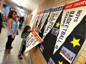 Lina Tannous and her daughter Tania Tannous help themselves to a banner during a farewell party for Queen of Peace Elementary School in Leamington on Thursday, June 16, 2016. The school, which opened in 1961, will close after this school year.