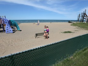 Pam McCormick supervises her children, Austin, 4, and Kelsey, 3, at Sand Point beach.  Chain link fencing with a dark green insert, was installed to deter gawkers on Riverside Drive East at Sand Point beach June 3, 2016.