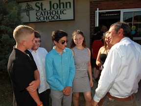 St. John Catholic Elementary School students chat with longtime teacher Paul Lapa, right, on  June 17, 2016. An open house, outdoor mass and reception for the school community was held and Lapa was chosen to turn out the lights for the last time.