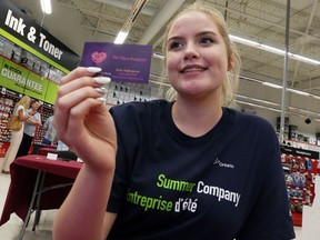 Kylie Baillargeon holds up her business card for Pet Place Products during the Staples Summer Company Youth Entrepreneurship Day at the Walker Road Staples store in Windsor, Ontario on June 29, 2016.