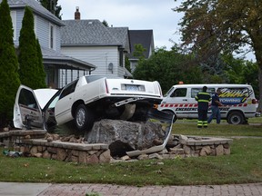 A white Cadillac Deville crashed into a rock foundation on the front lawn of a house on Sandwich Street in Amherstburg on Thursday, July 14, 2016. The single-vehicle crash sent one man to hospital with minor injuries. The 72-year-old driver travelling north on Sandwich Street lost control of the vehicle before crashing into the structure. (JULIE KOTSIS/Windsor Star)