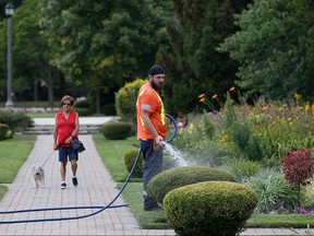 City of Windsor summer student Aaron Bidnuz, waters flowers and shrubs at Jackson Park on July 26, 2016.
