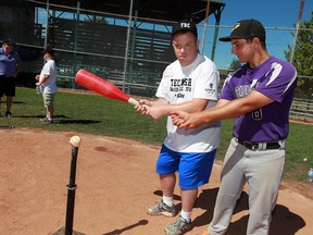 Tecumseh Thunder player Casey Boutette, right, assists Alvin Matte at home plate during annual Tecumseh Baseball Club's Fun Day Camp for challenged players at Lacasse Park July 26, 2016.