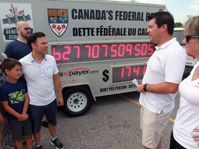 Christine Van Geyn, right, and Aaron Wudrick, both of the Canadian Taxpayers Federation chat with Amherstburg's Anthony Leardi, centre, and child Andrew, 9, Thursday July 14, 2016.