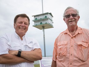 John Balga, left, and Tim O'Hagan, members of the Colchester Purple Martin Project, are pictured next to a Purple Martin House at Colchester Harbour Marina, Sunday, July 24, 2016.  The project is an initiative designed to combat the bird's decline.