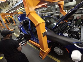 In this March 14, 2014, file photo, an assembly line worker builds a 2015 Chrysler 200 automobile at the Sterling Heights Assembly Plant in Sterling Heights, Mich.