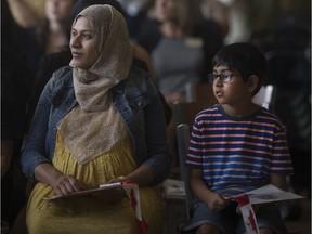Maryam Naseem, left, and her son, Arham Haq, 9, attend the Canada Day Immigration, Refugee and Citizenship swearing-in ceremony at the Windsor International Aquatic and Training Centre, Friday, July 1, 2016.