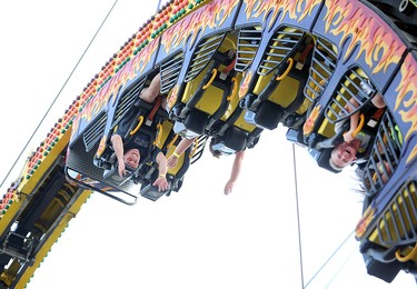 Essex Fun Fest attendees ride upside down on an amusement ride in Essex, Ontario on July 7, 2016.