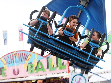 Brian Mulcaster, Lucas Laramie, and Jimmy Hayes enjoy an amusement ride during the 2016 Essex Fun Fest in Essex, Ontario on July 7, 2016.