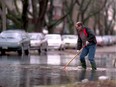 February 25,2001. City of Windsor sewers supervisor Rick Apolloni tries to poke free a blockage in a storm sewer that caused Partington Avenue to flood Sunday. Leaves blocked the sewers after the heavy rains of Saturday night. Ted Rhodes.