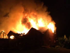 Flames shoot from the roof of a home in the 3300 block of Middle Side Road in Amherstburg on July 5, 2016.