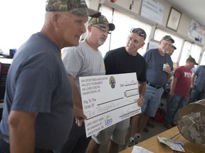 From left, Bill Richards, Rodney Ferriss, and winner of the $10,000 draw at the AMA Sportsmen's walleye Tournament, Chris Bondy, pose for a photo at the AMA Sportmen's Association, Sunday, July 3, 2016.