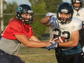 Ravens QB Daniel Metcalfe, left, hands the ball off to RB Braeden Braccio during team workout on July 19, 2016.