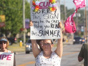 Striking CUPE library technician Michelle Griffiths pickets in front of the Tecumseh municipal building on Tuesday, July 12, 2016.