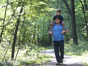Alan McKinnon and his son Benjamin walk through the Ojibway Park on July 19, 2016.