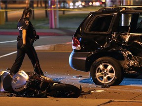 A Windsor Police officer investigates the scene of a serious accident between a motorcycle and an SUV on Tecumseh Road East near Enterprise Way. The motorcyclist was taken to hospital with life-threatening injuries according to police on scene.  (DAN JANISSE/The Windsor Star)