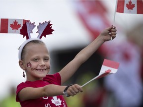 Natalie Introcaso, 7, waves Canadian flags as the floats pass by at the Canada Day Parade on Wyandotte Street East in downtown Windsor, Friday, July 1, 2016.