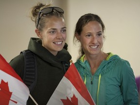 Olympic track stars Melissa Bishop, left, and Noelle Montcalm, pose for a photo as they return to Windsor at Windsor International Airport, Saturday, July 16, 2016.