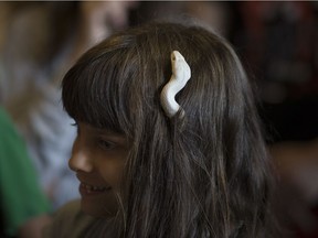 Olivia Gut, 7, has a corn snake slither through her hair at the Ojibway Nature Centre's World Snake Day celebration, Saturday, July 16, 2016.