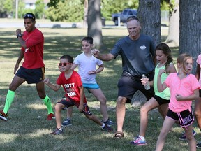 Local triathlon organizer and competitor John McKibbon, centre, and instructor Prakash Pandya left, do drills with participants in the Kids of Hospice triathlon camp in Tecumseh on July 27, 2016.