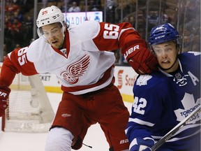 Toronto Maple Leafs Tyler Bozak (42) gets checked by Detroit Red Wings Danny DeKeyser  (65) in an NHL game on April 2, 2016 at the Air Canada Centre in Toronto.