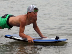 Connor McCracken, 12, cools off while body surfing on Lake St. Clair at Sand Point beach Monday July 11, 2016.