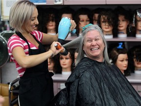 Hospice patient Lorna Lennox, right, smiles with other patients as St. Clair College hairstyling student Cori Dufresne uses her hair dryer to complete the job July 19, 2016.